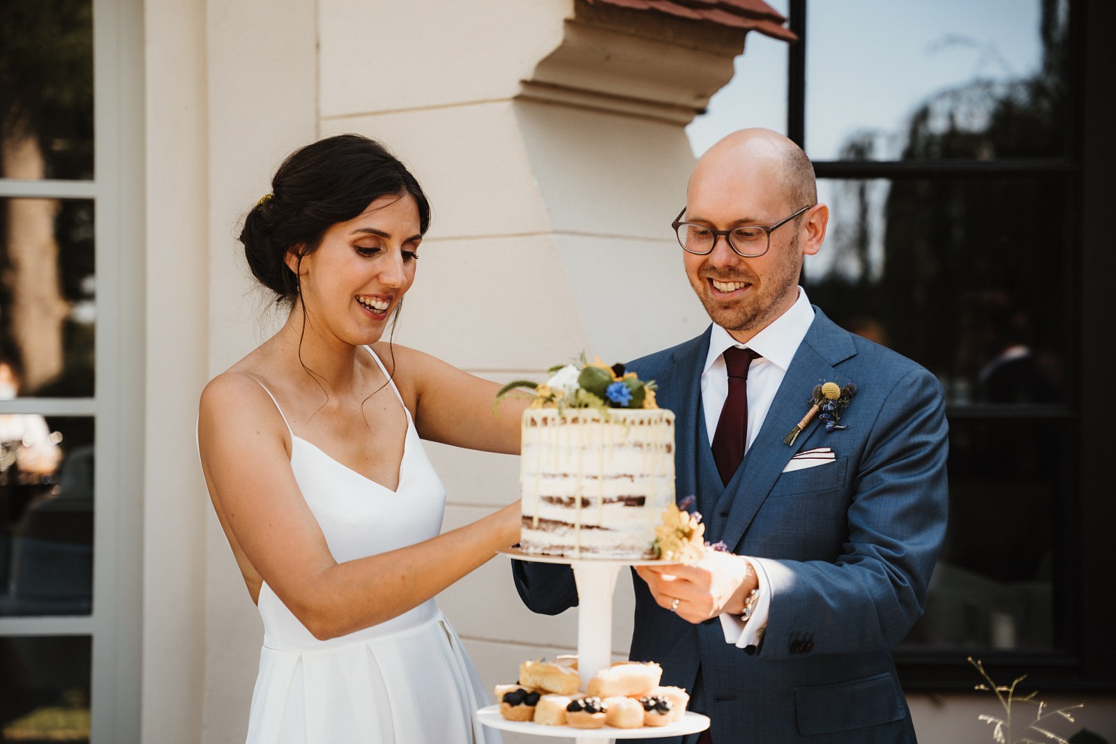 Brautpaar schneidet Hochzeitstorte in der Hochzeitslocation Remise am Schwielowsee